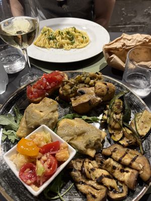 Veggie platter with vegan lemon pasta in the back  at Ristorante Grano Libero in Pisa