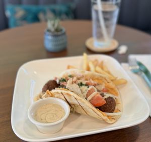 Falafel sandwich on pita bread with fries  at Pistachio Kitchen in San Francisco