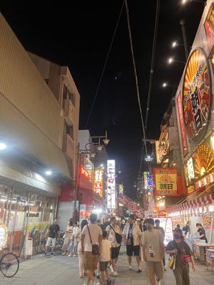 Allley to restaurant leads to an arcade type area with shops and there are stalls with shaved ice and fruit coated in candy for desert   at Shinsekai Paprika Shokudo Vegan in Osaka