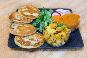 Plate of O-Marie including some alu-ko-aachar (nepali version of potato pickle/salad), sauce and salad. at MoMo House in Westminster