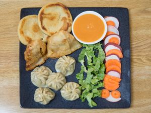 A combination plate with 5 MoMo, 2 O-Marie and 2 Samosa plus some salad and sauce. at MoMo House in Westminster