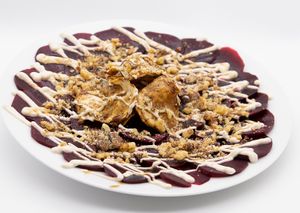 Beetroot carpaccio with pomegranate syrup, walnuts and celeriac chips. at Feinberg's in Berlin