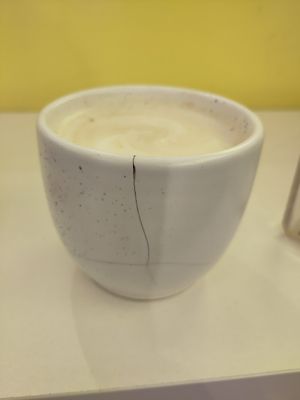 Badly cracked cup of soya latte at Areca Bakery in Barcelona