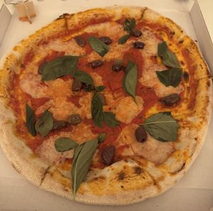 Pizza with olives and basil  at HOT PLANTS in Prague