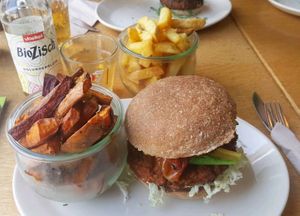 Grünkern-Mandel-Burger mit Salat, Avocado, gegrillte rote Paprika, Salatgurke, Gehörtketchup, Orangen-Curry-Soße, Petersilie  und Süßkartoffelpommes  at Wiesenlust in Frankfurt