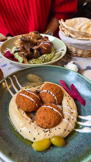 Classic hummus and falafel, and basil hummus with mushrooms, kibbeh and cauliflower in the background at The Hummus Connection  in Nuremberg