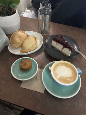 Dos empanadas, frutas rojo cheesecake, un café y little cookie sandwich  at La Loca de Enfrente in Madrid