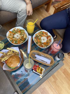 On the right- vegetable curry, on the left- vegan chickpea burger, all drinks are vegan (juice/ smoothie w/ soy milk)  at La Casa de Bamboo in Huacachina