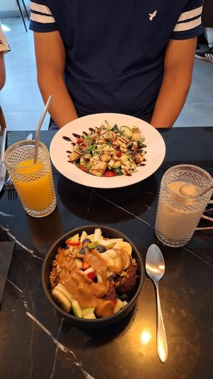 Açai bowl and grilled tofu salad. Decaf iced coffee with oat milk & fresh orange juice at Euphoria Coffee & Brunch in Cascais