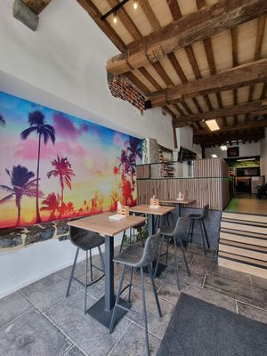 High tables and bar chairs / front of restaurant at Oké Poké  in Oudenaarde