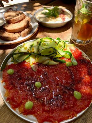 Tomatoes carpaccio and hummus  at Meshek Barzilay in Tel Aviv