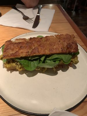 Homemade focaccia filled with avocado, homemade kimchi, and lettuce   at Rasoterra in Barcelona