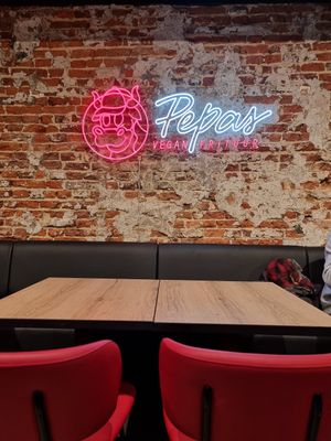 Seating and logo at Pepas Vegan Frituur in Leuven