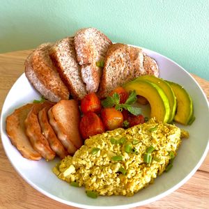 Hearty breakfast: Creamy scrambled tofu, avocado, roasted vegan paté and tomatoes with sliced whole grain bread at Cambodhi in Kampot