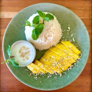 Mango Sticky Rice: Sticky rice made with coconut milk. Served with mango and a coconut pandan sauce. at Cambodhi in Kampot