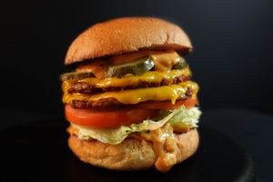 Double Impossible with double cheddar cheese, Nabati sauce, tomatoes, shredded lettuce, and pickles. Served with fries on the side.
 at Nabati Bistro in Dubai