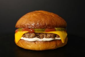 Impossible patty with ketchup, mayo, cheddar cheese, and pickles. Served with fries on the side.
 at Nabati Bistro in Dubai