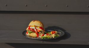 Fondue burger made with vegan home made fondue cheese sauce, sour dough vegan bread, caramelized onion with salad or french fries on the side. at El Exceso Food Truck in Mexico City