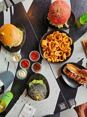 Chicken burger (the pink one), truffle burger (the black one), cheeseburger and coloured hotdog + curly fries + 4 sauces (bbq & garlic are the best) at Vegan Pirates by CloudEatery in Berlin