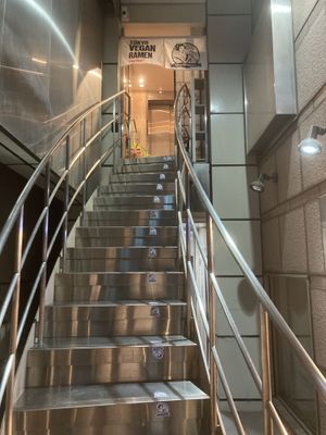 Go up here  at Tokyo Vegan Ramen Center in Tokyo