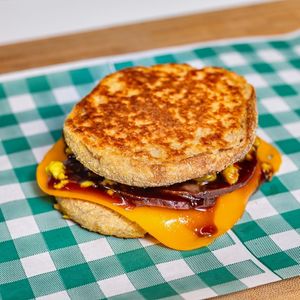 Toasted wholemeal English inside-out muffin filled with scrambled eggy tofu, vegan cheddar, smokey BBQ sauce and your choice of vegan bacon or sausage patties. at Feelyoucan Takeaway - Maybe closed in Bankstown