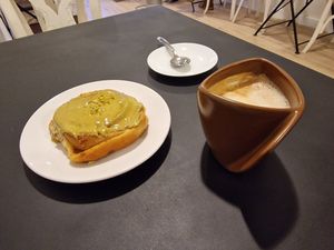 Pistachio cinnamon roll with cafe con leche at Natury in Barcelona