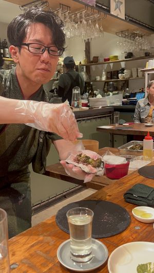 Chef adding the cherry blossom powder to the sakura-broccoli hand roll  at veggie tempo & sushi in Tokyo