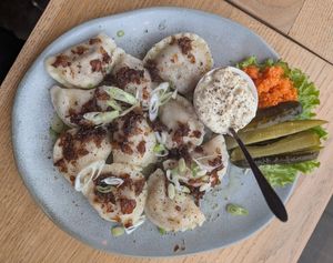 Mix of savory pierogi: chilli sin carne and smoked tofu, with fried onions, vegan sour cream, shredded carrot, and dill pickles on the side at Kemuri in Reykjavik