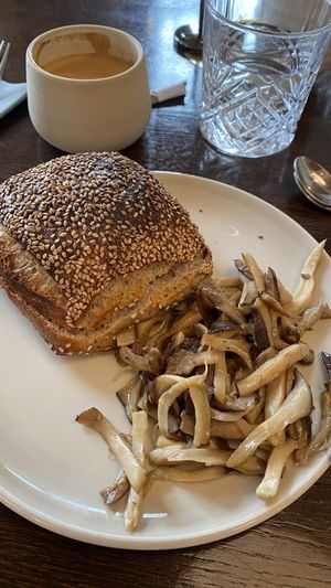 Mushrooms with bread roll and oat latte  at Rug Bakery in Copenhagen