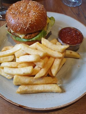 Garden Vegetable Burger: Garden vegetable & grain burger pattie topped with oven roasted peppers. Served with chips & smoky tomato chutney (added slice of vegan cheese) at De Trafford Arms Hotel in Alderley Edge