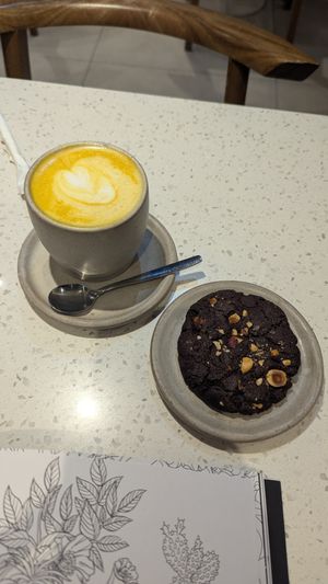 Golden milk latte y cookie de chocolate con avellanas at Nueza in Buenos Aires