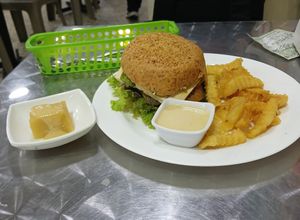 Hamburguesa vegana (pan integral, tofu, proteína de garbanzos y lentejas, lechuga, tomate y pepinillos) con papas, 8/10 at Tienda & Cocina Vegetariana in Medellin