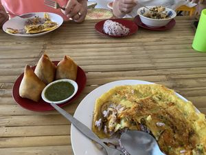 Chickpea omelet, samosas with coriander chutney, kimchi bowl  at Free Bird Cafe Pai in Pai