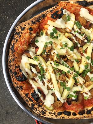 Hot Dog Pizza with baked potatoes: tomato sauce with Dijon mustard, pickled cucumber, craft wheat-tofu sausages, French fries (baked), green onions, cashew sauce, fried onions at Daner Pizza in Tbilisi