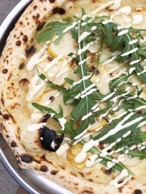 Pear pizza: "cream" sauce, vegan mozzarella, sweet pear, pine nut, arugula, cashew sauce at Daner Pizza in Tbilisi