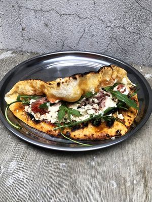 Vegan pizza sandwich w/homemade ricotta: garlic pizza bread, tomato sauce, arugula, tofu-ricotta, cherry tomatoes in balsamic, pickled onions, cashew sauce at Daner Pizza in Tbilisi