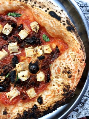 Luxury vegan pizza with tomato sauce, basil, garlic, sun-dried tomatoes, cashew-camembert and olive oil at Daner Pizza in Tbilisi