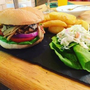 Dirty stop out burger with hot sauce and tzatziki with chips and coleslaw . at Samphire Brasserie in Plymouth
