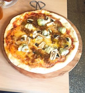 Pizza Bruta (tomate, mozzarella, champiñones, alcachofas y cebolla pochada) at La Galla Tasca Vegana in Barcelona