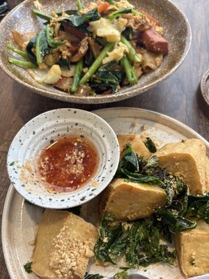 stir fried noodles with soy sauce and kale (back) and fried tofu appetizer with kaffir leaves and lime (front)   at PLANT Passion in Bangkok