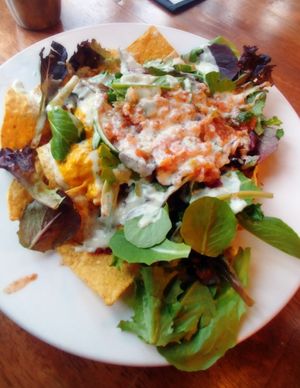 Nachos ~ Black Bean Chili, (vegan) Creamy Cheddar Cheese Sauce, Fresh House Salsa, Greens, Topped with a Swirl of Ranch.  at Kitchen 17 in Chicago