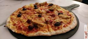 Vegan pizza, "la fabuleuse", tomato sauce, marinated peppers, kalamata olives, aiguillettes (Happyvore) and vegetable rapé, espelette pepper at La Pizza de Nico in Paris