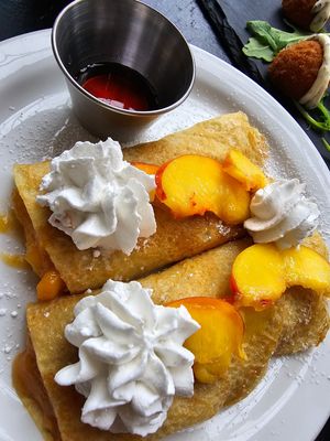peaches & cream crepes - vegan crepes, cooked peach filling & fresh peach topping, vegan whipped cream, maple syrup, powdered sugar at Mad Rabbit Cafe in Madison