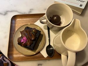 Chocolate cake and hot chocolate with oat milk   at Bloom Café in Lille