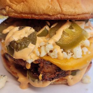 San Diego,  blue cheese, jalapeños, slice cheese,  seasoned patty topped with Chipotle sauce  on a toasted bun at Cosmic Bird in Louisville