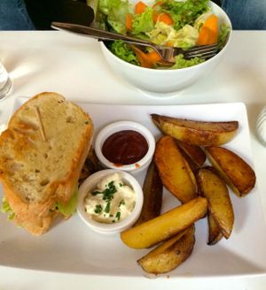 Burger (could be ordered with normal bun or homemade spelt bread), wedges, and salad. Yum. at Katzentempel - München in Munich