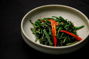 ผัดผักกูดไฟแดง   pad pak goot
stir-fried young fiddlehead ferns
 at Nahm  in Bangkok