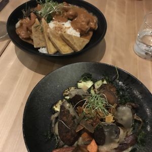 Sausage with celeriac purée, veg and wine sauce and butter chicken bowl at Invitation V in Montreal