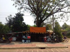 Reverse motor tricycle parked on left, front of the restaurant as seen from the city wall side of the street at Lan Gae in Chiang Saen