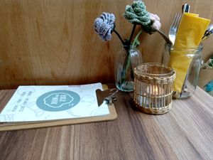 Table with menu, candle, cutlery and decoration at Koek van Nouk in Arnhem